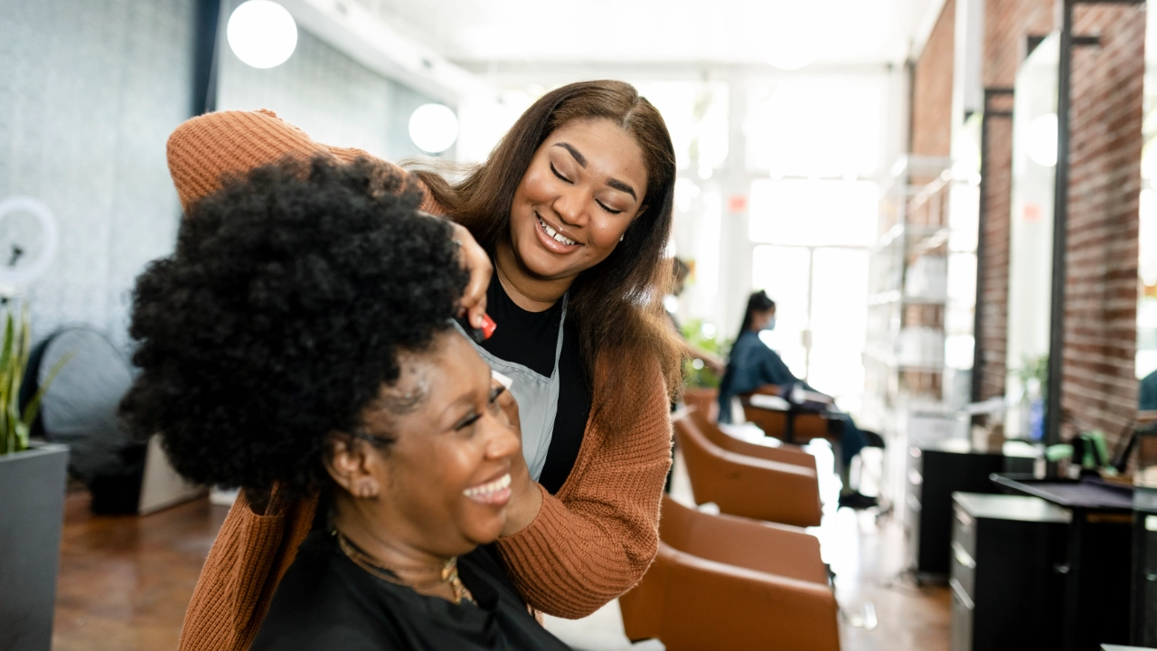 young black woman getting her hair done in a salon