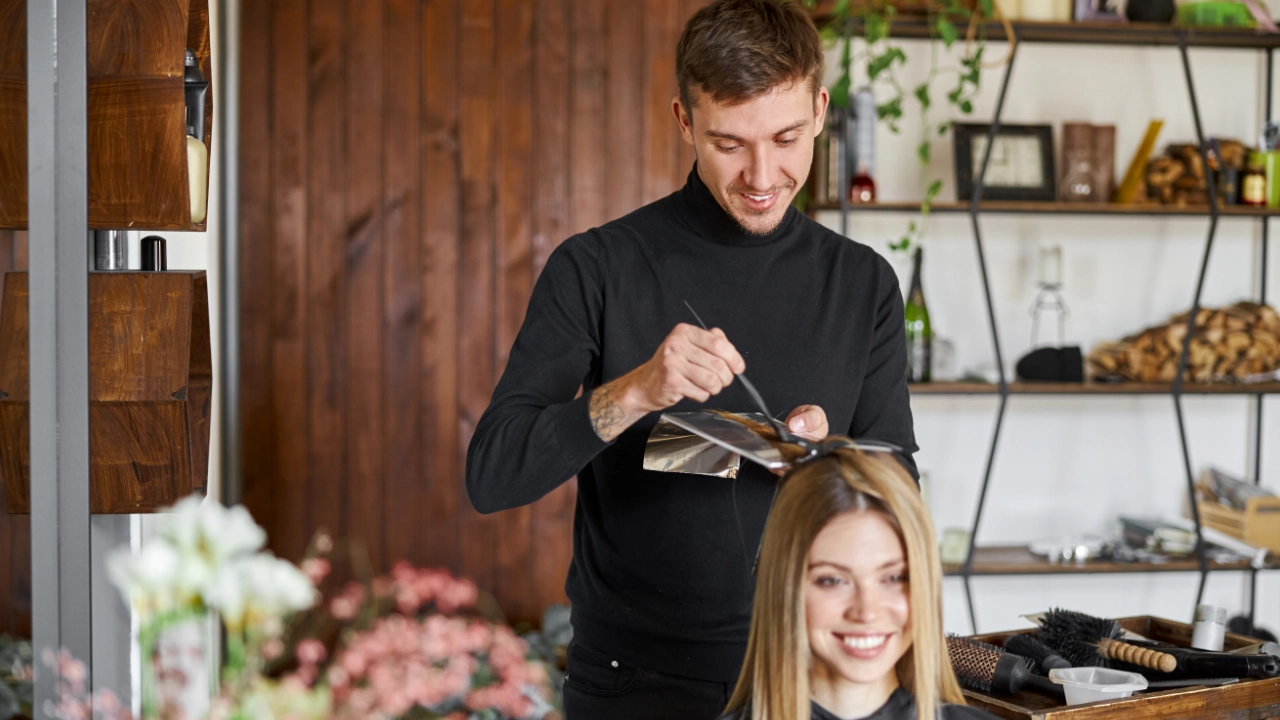 young woman getting hair coloration done by a young color specialist