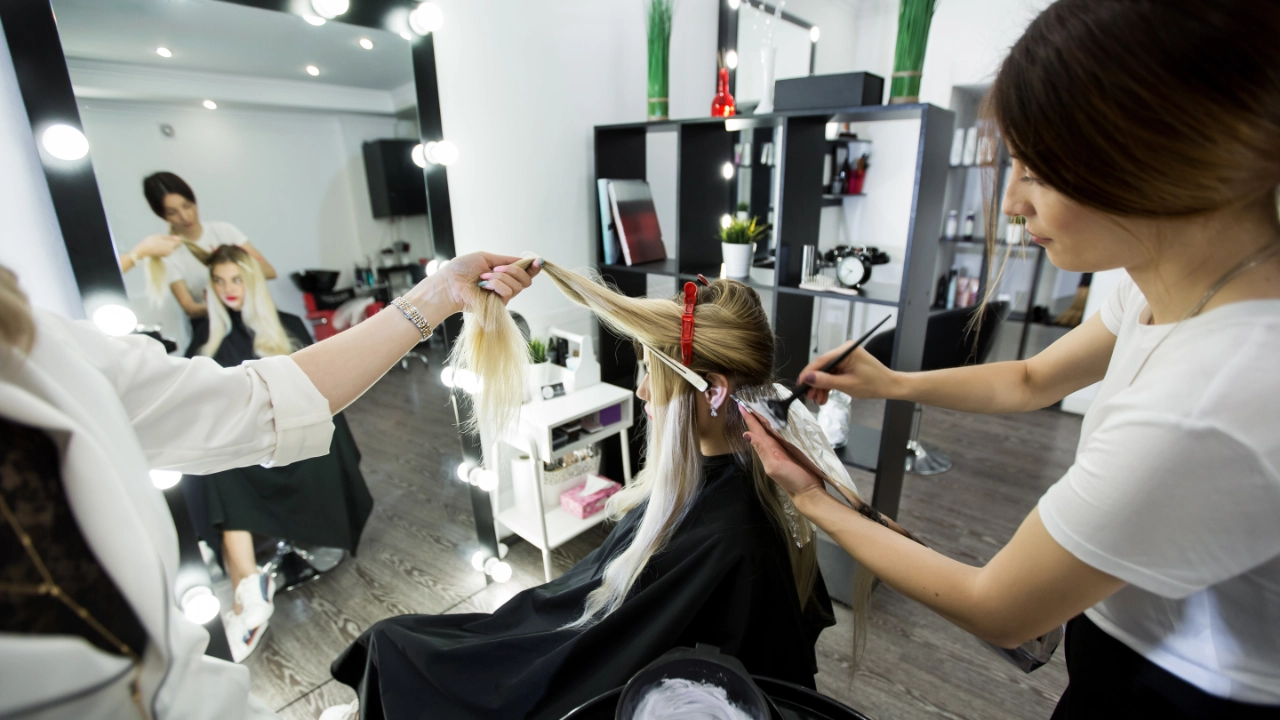young woman getting having her hair color done by a stylist