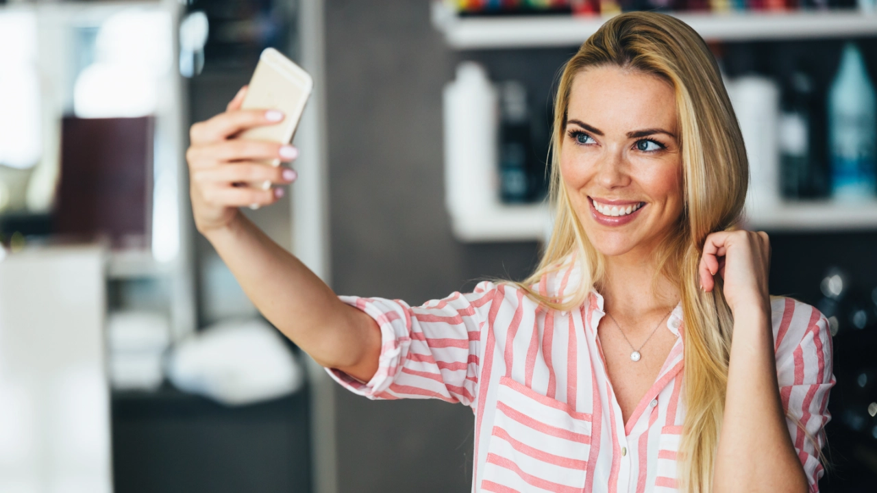 young woman taking a selfie before leaving a beauty salon